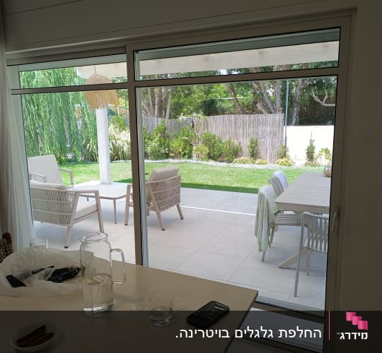 חלון זכוכית עם נוף לגינה ירוקה
